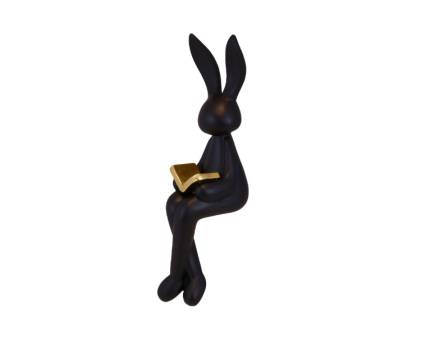 Iepuras negru sezand cu carte aurie